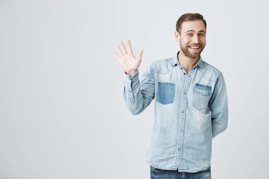 Blonde man waving and greeting with Dutch phrases